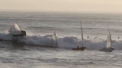 Una ola grande y brusca en marea alta golpea a 4 veleros con ni&ntilde;os que se dirig&iacute;an al puerto de Santa Cruz (California, Estados Unidos) en enero del 2021. Al fondo, un grupo de surfistas aguarda tambi&eacute;n olas para surfear. 