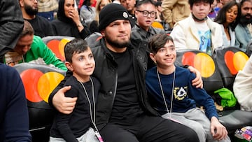 Mar 1, 2024; Toronto, Ontario, CAN; Former Russian mixed martial artist Khabib Nurmagomedov poses with two young fans during a break in the action between the Golden State Warriors and Toronto Raptors at Scotiabank Arena. Mandatory Credit: John E. Sokolowski-USA TODAY Sports