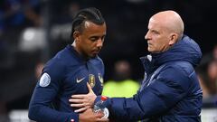 France's defender Jules Kounde (L) is consoled by France's assistant coach Guy Stephan after he was injured during the UEFA Nations League, League A Group 1 football match between France and Austria at Stade de France in Saint-Denis, north of Paris, on September 22, 2022. (Photo by FRANCK FIFE / AFP)