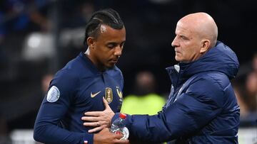 France's defender Jules Kounde (L) is consoled by France's assistant coach Guy Stephan after he was injured during the UEFA Nations League, League A Group 1 football match between France and Austria at Stade de France in Saint-Denis, north of Paris, on September 22, 2022. (Photo by FRANCK FIFE / AFP)