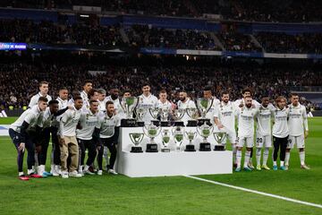 Los jugadores del Real Madrid posan con los trofeos conseguidos por Amancio Amaro.