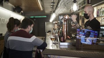 Un camarero sirve una cerveza en el interior de un bar