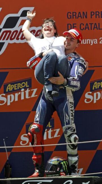 El piloto español de MotoGP Jorge Lorenzo, celebra en el podio su victoria en el Gran Premio de Cataluña, acompañado de la diseñadora Anna Vives, creadora de la tipografía del Casco que Lorenzo utilizó para esta carrera en Montmeló.