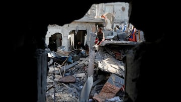 A child sits amid rubble as Palestinians inspect the site of an Israeli strike on a house, in Khan Younis in the southern Gaza Strip March 18, 2025. REUTERS/Hatem Khaled