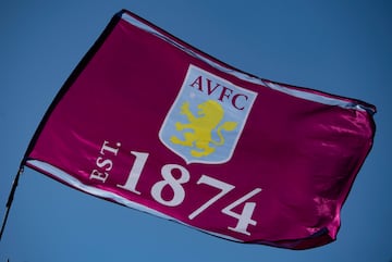 El Aston Villa es un equipo histórico en Inglaterra con más de 100 años de antigüedad, uno de los ‘padres fundadores’ del fútbol inglés. Este club fue fundado en 1874 y es uno de los miembros fundadores de la Football League. El mote de este equipo es ‘Villans’ y su origen se encuentra en Villa Cross Wesleyan Chapel, una antigua iglesia parroquial ubicada en Birmingham. Fue construida por el arquitecto James Murray en 1863 y consagrada por Henry Philpott, obispo de Worcester. La iglesia destacó por tener un club de rugby que jugó un partido contra un equipo de Villa Cross Wesleyan Chapel en Handsworth, en Birmingham. El equipo de Villa jugó la primera parte bajo las reglas del rugby y la segunda con las reglas del fútbol. Esta iglesia fue demolida en la década de 1970, pero el apodo de “The Villans” sigue vigente en el equipo. También recibe el mote de “The Claret and Blue Army” ya que en su equipación combina los colores azul cielo y vino, donde también aparecen en el escudo junto a un león de color amarillo en el centro, así que también son conocidos como “The Lions”. Sin embargo, el mote más común del Aston Villa es el primero de todos.