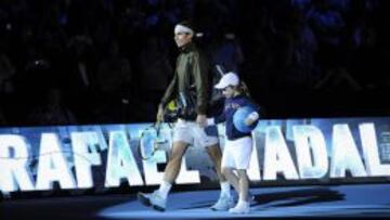 Nadal llega a la pista acompañado por una niña para disputar un partido de la Copa de Maestros.