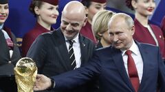 FILE - Russian President Vladimir Putin touches the World Cup trophy as FIFA President Gianni Infantino stands beside him, at the end of the final match between France and Croatia at the 2018 soccer World Cup in the Luzhniki Stadium in Moscow, Russia, Sun