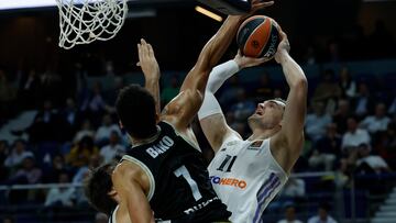 MADRID, 27/10/2022.- El alero croata del Real Madrid Mario Hezonja (d) intenta anotar ante la defensa de Ismaël Bako (c), pívot belga de la Virtus de Bolonia, durante el partido de la quinta jornada de la EuroLiga que se disputa hoy jueves en el WiZink Center, en Madrid. EFE/Juanjo Martín