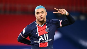Paris Saint-Germain's French forward Kylian Mbappe, with blue hair, flashes the "V" for victory, during the French L1 football match between Paris-Saint Germain (PSG) and FC Lorient at The Parc des Princes Stadium in Paris on December 16, 2