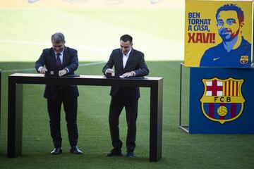 Xavi Hern¨¢ndez y Joan Laporta durante la firma de contrato.
