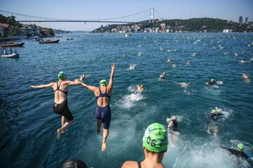 Los nadadores saltan en el estrecho del Bósforo mientras participan en el evento Continental Swin de Bosphorus. La carrera lleva a los participantes por los 6 kilómetros del estrecho del Bósforo desde el lado asiático de Estambul a la parte europea
