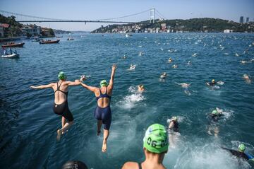Los nadadores saltan en el estrecho del B¨®sforo mientras participan en el evento Continental Swin de Bosphorus. La carrera lleva a los participantes por los 6 kil¨®metros del estrecho del B¨®sforo desde el lado asi¨¢tico de Estambul a la parte europea