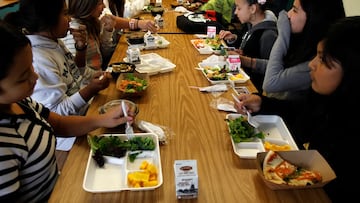Estudiantes comiendo una opción de almuerzo saludable.