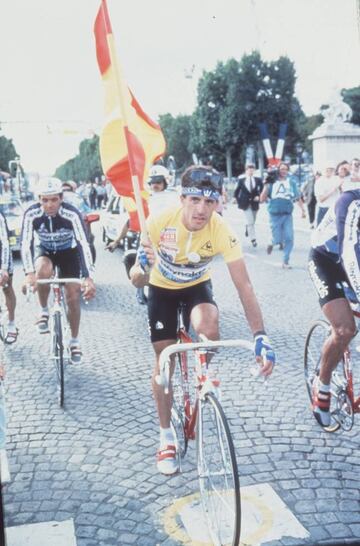 Perico Delgado, campe&oacute;n del Tour de Francia en 1988, con la bandera de Espa&ntilde;a y vestido de amarillo por los Campos El&iacute;seos.