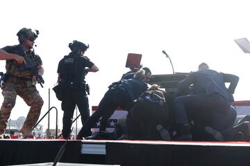 El expresidente, Donal Trump, es evacuado por el servicio secreto del estrado, con algo de sangre en el rostro, tras escucharse disparos. El candidato republicano ha salido por su propio pie con el pu?o en alto.