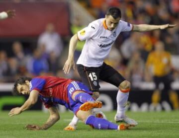 El centrocampista del Valencia Javi Fuego (d) junto al centrocampista argentino del Basilea Matías Delgado (i), durante el partido de cuartos de final de la Liga Europea, disputado hoy en el estadio de Mestalla.