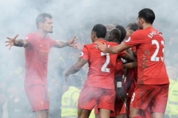 El croata Dejan Lovren aparace entre el humo de una bengala para celebrar junto a sus compañeros el gol de la victoria de Sadio Mané en el tiempo añadido del derbi de Liverpool. 