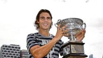 <b>EN LA SENDA DE ROD LAVER. </b>En Melbourne Park, Yarra, junto al Laver Arena, y con fondo de rascacielos, Rafael Nadal alza el trofeo de Australia: tras los pasos de Rod Laver.