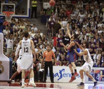 El jugador del FC Barcelona Juan Carlos Navarro lanza a canasta ante Sergio Llull.