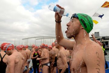 A participant pours water on his head before jumping into the water during the 108th edition of the 'Copa Nadal' (Christmas Cup) swimming competition in Barcelona's Port Vell on December 25, 2017.  
The traditional 200-meter Christmas swimming race gathered more than 300 participants on Barcelona's old harbour.   / AFP PHOTO / Josep LAGO