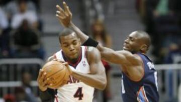 Paul Millsap captura un rebote ante Bismack Biyombo.