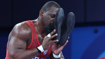 Paris 2024 Olympics - Wrestling - Men's Greco-Roman 130kg Final - Champ-de-Mars Arena, Paris, France - August 06, 2024. Mijain Lopez Nunez of Cuba kisses his shoes after winning gold in the match against Yasmani Acosta Fernandez of Chile. REUTERS/Kim Kyung-Hoon