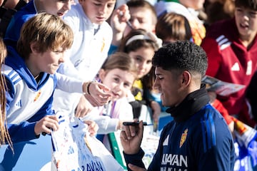 Adu Ares firma una camiseta.