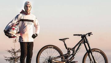 Àlex Marín posando con su bici y su casco para su nuevo equipo The Brigade MTB Team, que le acompañará a lo largo de la Copa del Mundo de Descenso de la UCI en 2020.