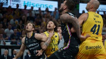 El jugador del Gran Canaria, Carrera (c) ante el ala-pívot del Lenovo Tenerife, Tim Abromaitis (i) durante el partido de baloncesto correspondiente a la liga ACB celebrado este domingo en el pabellón Santiago Martín de La Laguna (Tenerife).