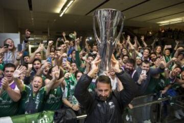 Joan Plaza, entrenador del Unicaja alzando el trofeo junto a los aficionados que les esperaron en el aeropuerto.