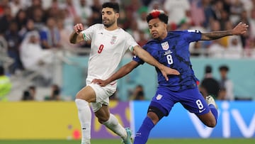 Iran's forward #09 Mehdi Taremi (L) fights for the ball with USA's midfielder #08 Weston McKennie during the Qatar 2022 World Cup Group B football match between Iran and USA at the Al-Thumama Stadium in Doha on November 29, 2022. (Photo by Fadel Senna / AFP)