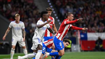 Real Madrid's Brazilian forward Vinicius Junior (L) fights for the ball with Atletico Madrid's Croatian defender Sime Vrsaljko (C) and Atletico Madrid's French forward Antoine Griezmann (R) during the Spanish League football between Club Atletico de Madrid and Real Madrid CF at the Wanda Metropolitano stadium in Madrid on May 8, 2022. (Photo by PIERRE-PHILIPPE MARCOU / AFP)