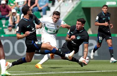 El jugador del Elche, Lucas Boyé, dispara a portería entre dos jugadores del Atlético de Madrid. 
