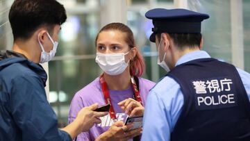 Belarusian athlete Krystsina Tsimanouskaya talks with a police officer at Haneda international airport in Tokyo, Japan August 1, 2021. REUTERS/Issei Kato