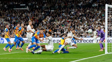 Kylian Mbappé y Jude Bellingham son sujetados dentro del área por defensores del Valencia durante una acción que terminó en penalti a favor del Real Madrid y abrió el marcador del encuentro con un gol de Mbappé.