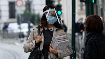 A woman wearing protective masks and face speaks to a woman along a street during the government restriction measures to curb the spread of COVID-19 novel coronavirus, in central Rome on November 5, 2020. (Photo by ANDREAS SOLARO / AFP)