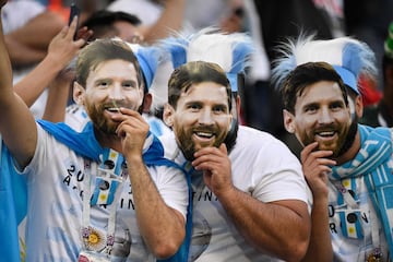 Hinchas argentinos con caretas de Leo Messi.