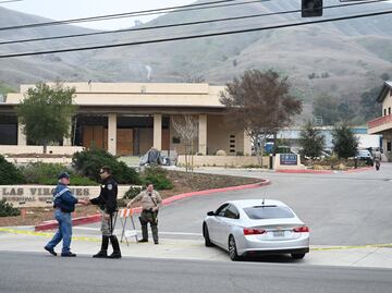 Un policía controla el acceso a la zona residencial de Las Vírgenes en Calabasas. Al fondo de la imagen, la columna de humo que señala el lugar del accidente del helicóptero en donde viajaba Kobe Bryant.