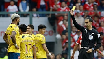 MEX6504. TOLUCA (MÉXICO), 30/11/2024.- El árbitro César Arturo Ramos muestra una tarjeta amarilla a Rodrigo Aguirre (i) de América este sábado, durante un partido de vuelta de los cuartos de final del torneo Apertura 2024 de la Liga MX entre Toluca y América, en el estadio Nemesio Diez en Toluca (México). EFE/ Felipe Gutiérrez