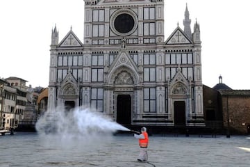 An employee of the municipal company disinfects the Piazza Santa Croce in front of Basilica Santa Croce, in Florence, on March, 21 2020.