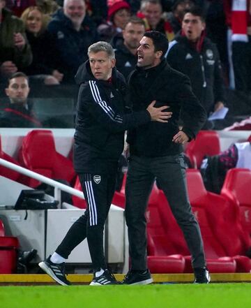 Mikel Arteta, entrenador del Arsenal, es frenado por un miembro de su cuerpo técnico.