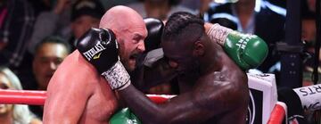 Tyson Fury y Deontay Wilder abrazados durante un lance de su trilogía.