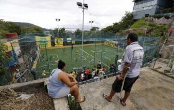 Residents watch the Copa Popular soccer tournament, or People's Cup, held between slums, at the Santa Marta slum in Rio de Janeiro April 27, 2014. About 10 slums participated in the sporting event La Copa del Pueblo, se celebra entre los barrios pobres, en la barriada de Santa Marta, en Río de Janeiro. Cerca de 10 barrios pobres participaron en el evento deportivo organizado por la República Popular de Comité para la Copa Mundial y los Juegos Olímpicos, una colección de los activistas de la sociedad civil y los movimientos obreros, para protestar contra los efectos de la especulación inmobiliaria causada por el flujo de capital que acompaña a la Copa Mundial 2014 y Juegos Olímpicos de 2016.