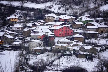 Vista panorámica desde Ponga de un conjunto de casas nevadas, a 18 de enero de 2023, en Ponga, Asturias (España). La Agencia Estatal de Meteorología (Aemet) ha elevado a naranja el nivel de alarma en Asturias, tanto por fenómenos costeros, como por acumulaciones de nieve que podrían ser de 20 centímetros en cotas superiores a los 1.000 metros. No solo los puntos más altos de la región se teñirán de nieve. La Aemet avisa de que hoy nevará por encima de los 300 metros en el interior y que en estos puntos podrían registrarse acumulaciones de hasta cinco centímetros de nieve.