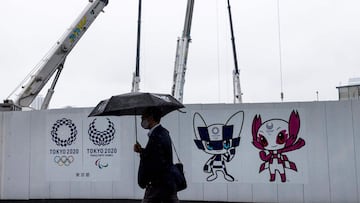 Un hombre con mascarilla pasa por delante de una zona de obras de los Juegos Ol&iacute;mpicos de Tokio.