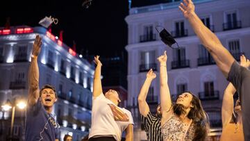 GRAF8203. MADRID, 26/06/2021.- Varias personas celebran el fin del uso obligatorio de la mascarilla en espacios abiertos en la Puerta del Sol, en Madrid. La orden del Ministerio de Sanidad por la que se elimina la obligatoriedad de usar mascarillas en la 