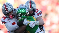 PASADENA, CALIFORNIA - JANUARY 01: Noah Whittington #6 of the Oregon Ducks is hit by JT Tuimoloau #44 and Jack Sawyer #33 of the Ohio State Buckeyes in the second quarter during the Rose Bowl Game Presented by Prudential at Rose Bowl Stadium on January 01, 2025 in Pasadena, California. Harry How/Getty Images/AFP (Photo by Harry How / GETTY IMAGES NORTH AMERICA / Getty Images via AFP)