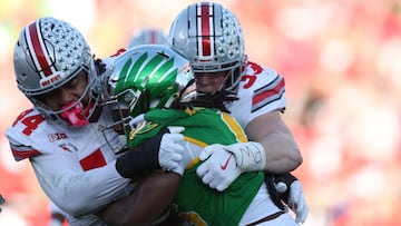 PASADENA, CALIFORNIA - JANUARY 01: Noah Whittington #6 of the Oregon Ducks is hit by JT Tuimoloau #44 and Jack Sawyer #33 of the Ohio State Buckeyes in the second quarter during the Rose Bowl Game Presented by Prudential at Rose Bowl Stadium on January 01, 2025 in Pasadena, California. Harry How/Getty Images/AFP (Photo by Harry How / GETTY IMAGES NORTH AMERICA / Getty Images via AFP)