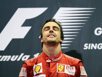 Winning Ferrari driver Fernando Alonso of Spain reacts during the awards ceremony on the podium for Formula One&#039;s Singapore Grand Prix at Marina Bay Street Circuit in Singapore on September 26, 2010. Alonso won an incident-packed Singapore Grand Prix ahead of Red Bull&#039;s Sebastian Vettel to put the world championship title race on a knife-edge. AFP PHOTO / Saeed KHAN (Photo credit should read SAEED KHAN/AFP/Getty Images)