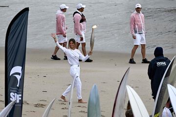 La surfista francesa Zoe Grospiron sujeta la antorcha olímpica durante el relevo en la playa entre Biarritz y Anglet.